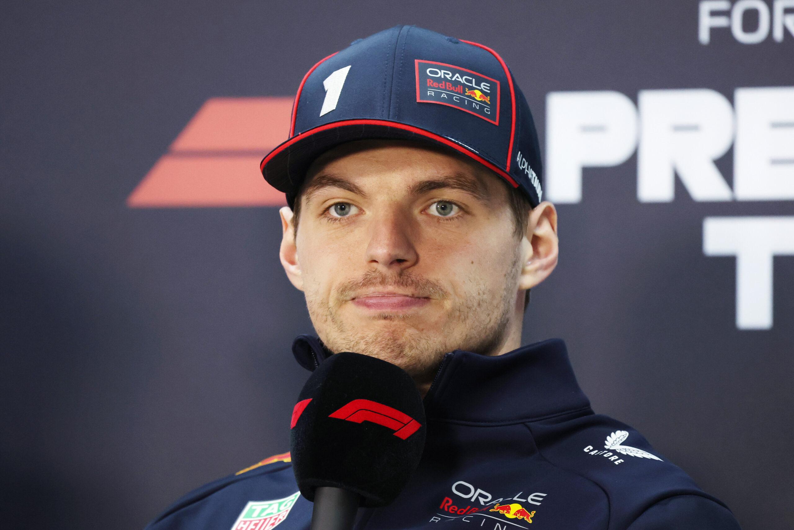 a man with a cap on and microphone in front of him